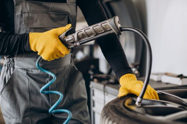 Mecanic umflă anvelopa auto cu pistol aer