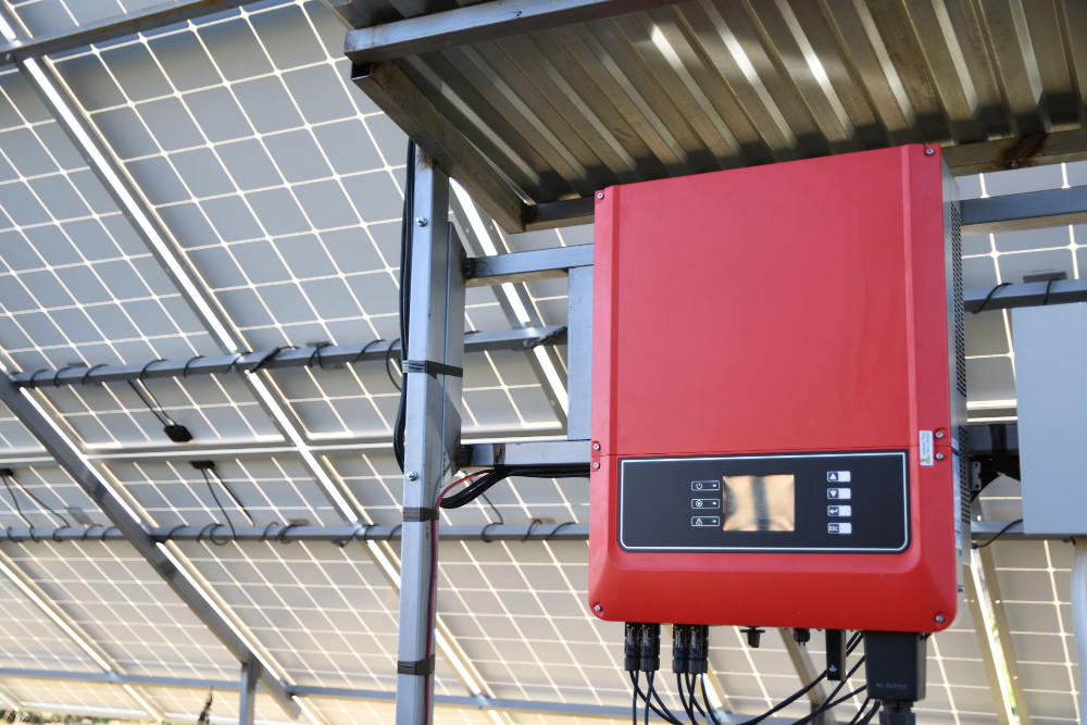 Invertor solar roșu montat sub panouri fotovoltaice